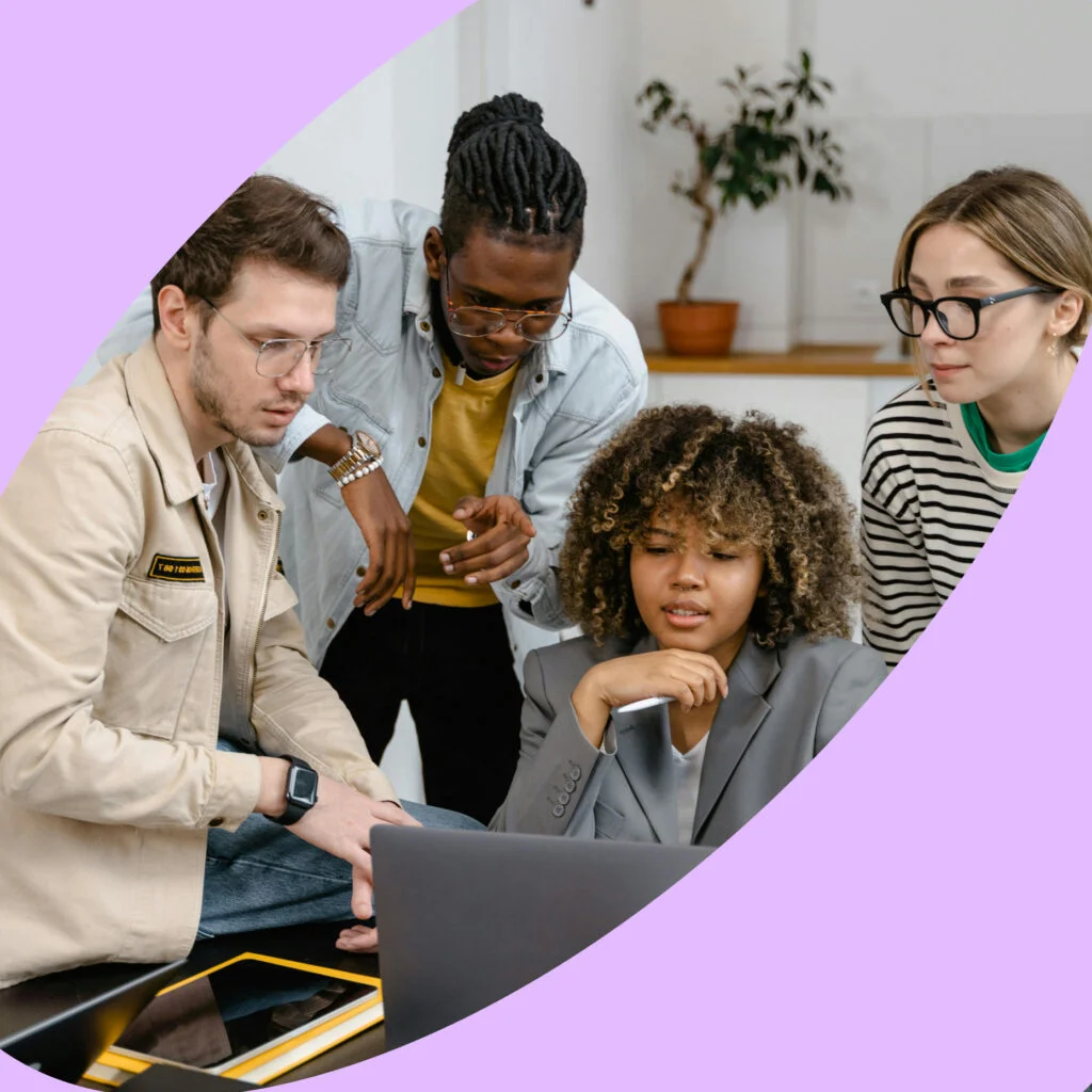 Group of people around a laptop working